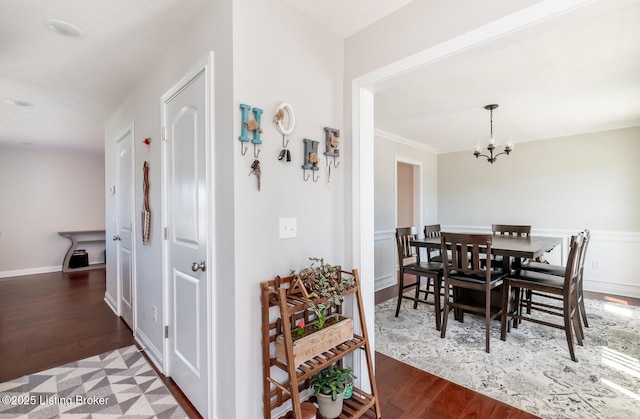 dining area featuring a chandelier, baseboards, and wood finished floors