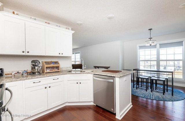 kitchen featuring dark wood-style floors, a peninsula, stainless steel dishwasher, white cabinetry, and a sink