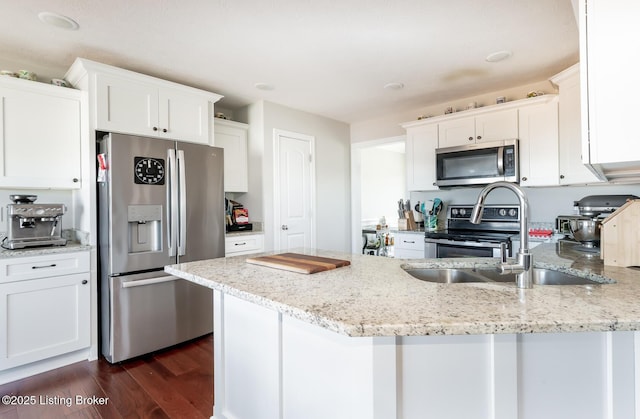 kitchen featuring a peninsula, light stone countertops, white cabinetry, and appliances with stainless steel finishes