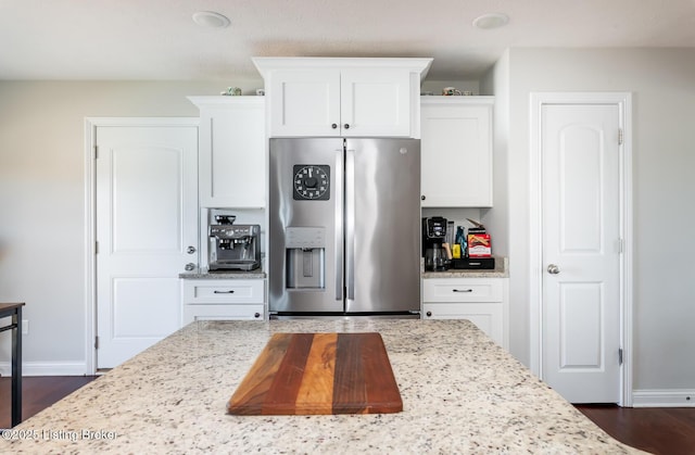 kitchen with baseboards, white cabinetry, and stainless steel refrigerator with ice dispenser