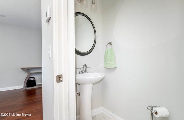 bathroom featuring a sink, baseboards, and wood finished floors