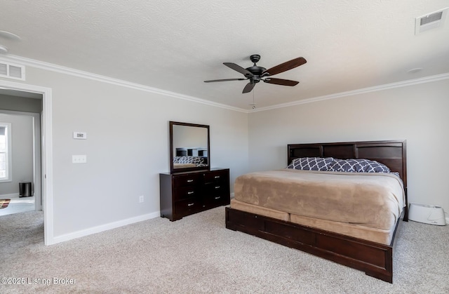 carpeted bedroom featuring a textured ceiling, ornamental molding, and visible vents