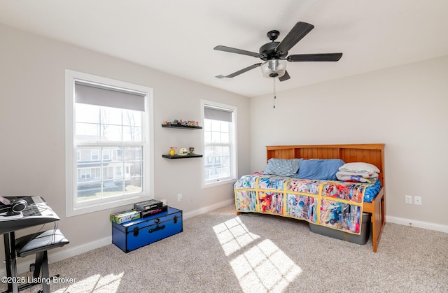 carpeted bedroom featuring baseboards and a ceiling fan