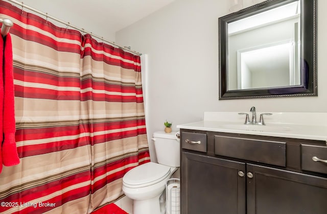 bathroom featuring a shower with shower curtain, vanity, and toilet