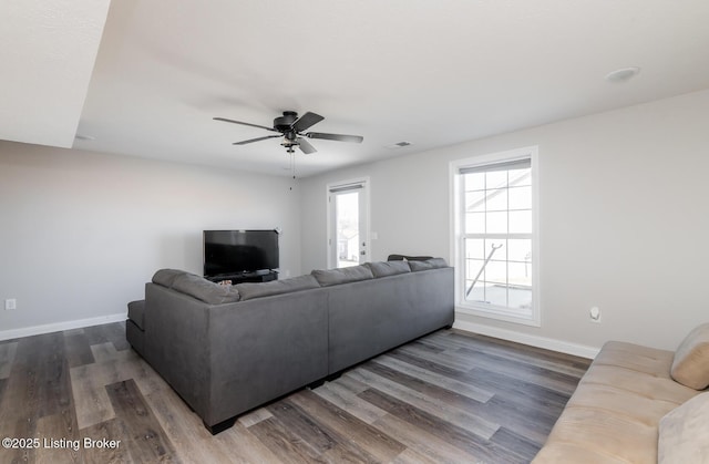 living room with a ceiling fan, visible vents, dark wood finished floors, and baseboards