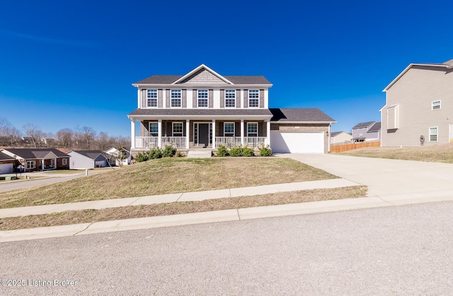 colonial inspired home featuring a porch, a front yard, concrete driveway, and an attached garage