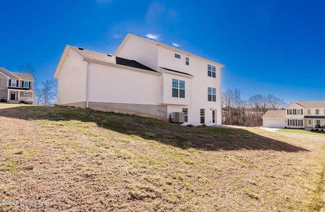 rear view of house with a lawn and central air condition unit