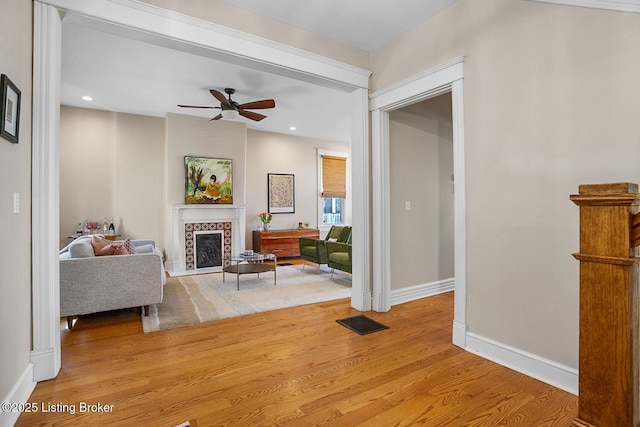 living room with light wood-type flooring and ceiling fan