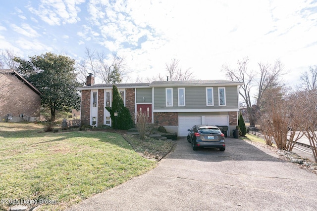 bi-level home featuring an attached garage, brick siding, driveway, a front lawn, and a chimney