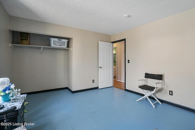 unfurnished room with baseboards and a textured ceiling