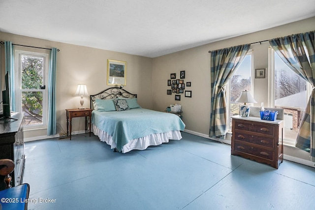 bedroom featuring baseboards and finished concrete floors