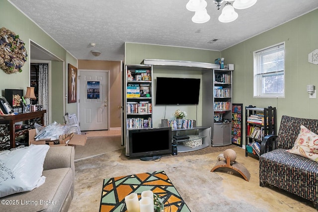 living area with visible vents, a chandelier, and a textured ceiling