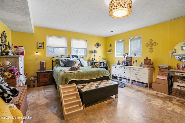 bedroom with concrete flooring and a textured ceiling