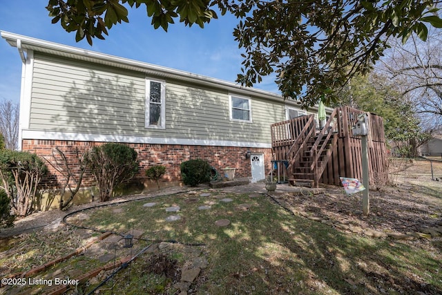 rear view of house with stairs, brick siding, and a deck