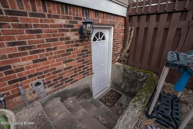 view of exterior entry with brick siding