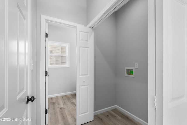 clothes washing area with washer hookup and light hardwood / wood-style flooring