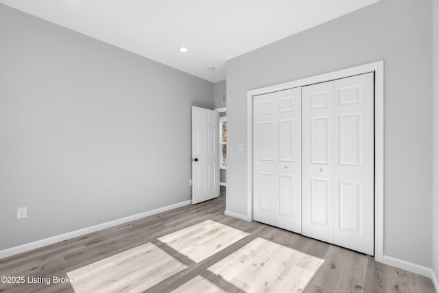 unfurnished bedroom featuring light hardwood / wood-style floors and a closet