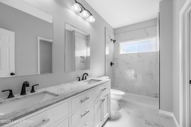 bathroom featuring vanity, tiled shower, and toilet