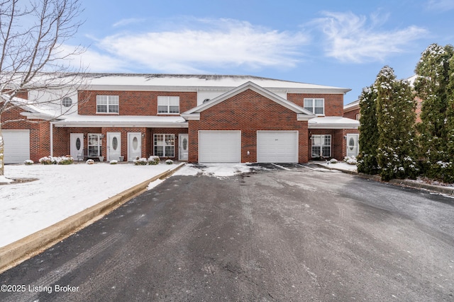 view of front of home with a garage, brick siding, and aphalt driveway