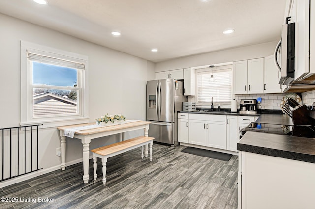 9914 Mccrea Ln, Louisville, KY 40229 - kitchen with appliances with stainless steel finishes, a sink, dark countertops, tasteful backsplash, and dark wood finished floors