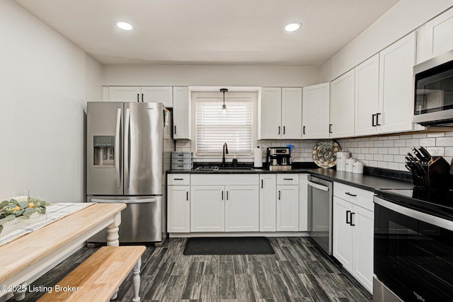 9914 Mccrea Ln, Louisville, KY 40229 - kitchen with stainless steel appliances, a sink, dark countertops, recessed lighting, and backsplash