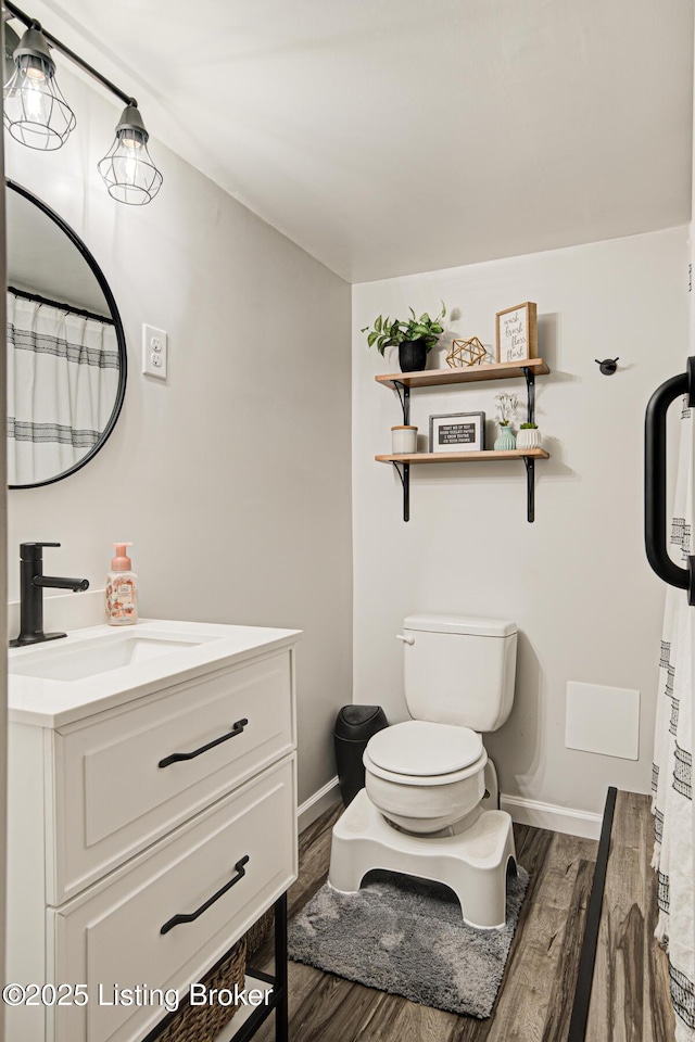 9914 Mccrea Ln, Louisville, KY 40229 - bathroom featuring wood finished floors, vanity, toilet, and baseboards
