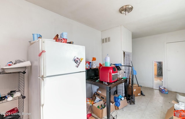 kitchen featuring white fridge and white cabinetry