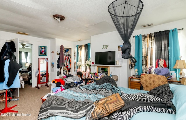 bedroom with multiple windows, carpet flooring, and a textured ceiling