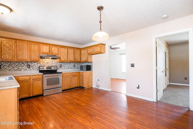 kitchen featuring decorative backsplash, electric stove, dark hardwood / wood-style flooring, and decorative light fixtures