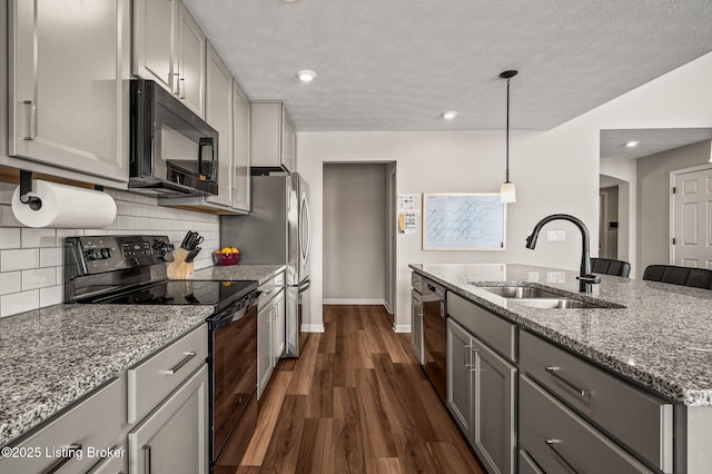 kitchen featuring dark wood-style floors, a sink, black appliances, and gray cabinets