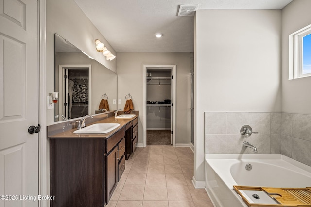 full bath with tile patterned floors, a bath, visible vents, and a sink