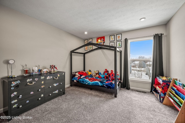 carpeted bedroom with baseboards and a textured ceiling