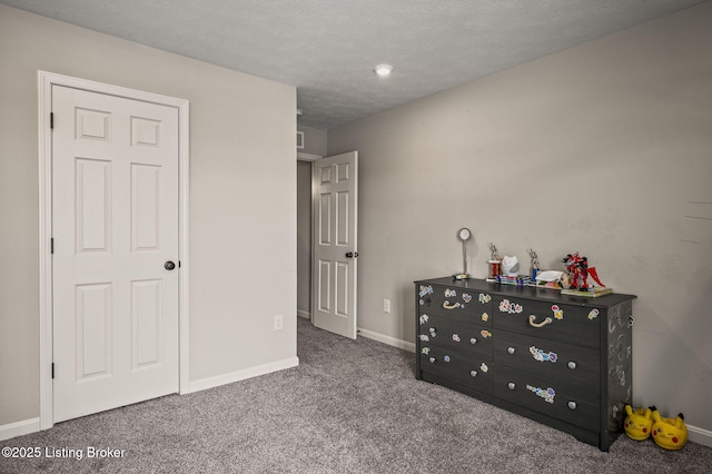 carpeted bedroom featuring baseboards and a textured ceiling