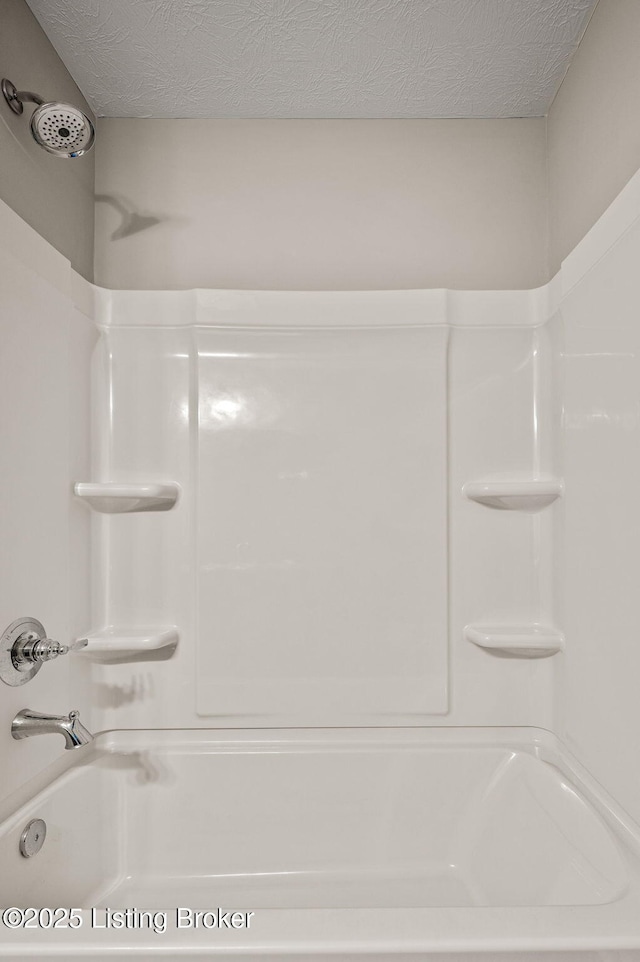 full bathroom with a textured ceiling and  shower combination