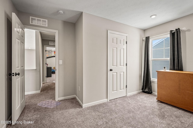 unfurnished bedroom featuring carpet, visible vents, and baseboards