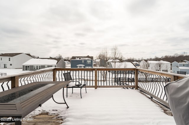 snow covered deck with a residential view