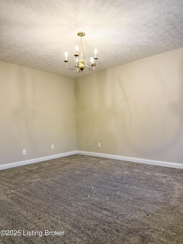 carpeted empty room featuring an inviting chandelier and a textured ceiling