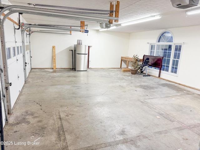 garage featuring stainless steel refrigerator and a garage door opener