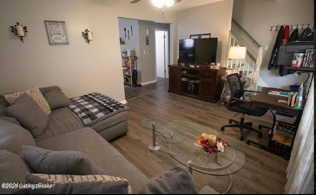 living room featuring ceiling fan and dark wood-type flooring