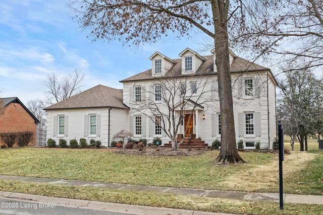 view of front facade with brick siding and a front lawn