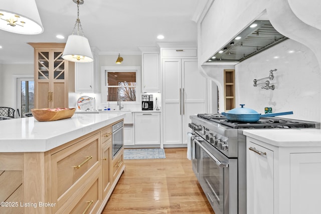 kitchen with light countertops, a kitchen island, high end range, and white cabinets