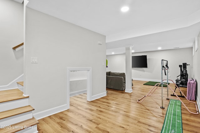 exercise area with baseboards, wood finished floors, and recessed lighting