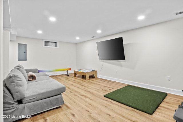 living area featuring recessed lighting, electric panel, visible vents, and wood finished floors