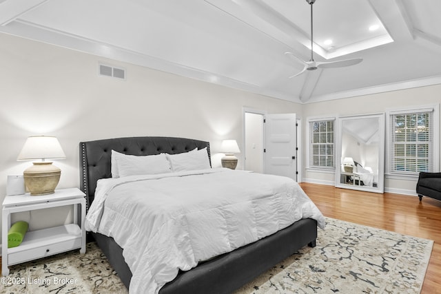 bedroom featuring lofted ceiling, visible vents, a ceiling fan, wood finished floors, and baseboards