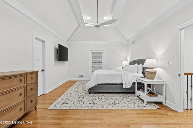 bedroom with light wood-style floors, lofted ceiling, visible vents, and crown molding