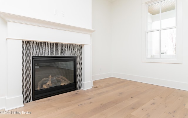 details with hardwood / wood-style floors and a tiled fireplace