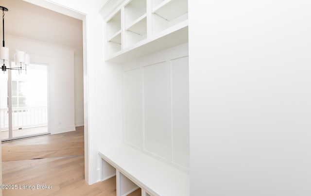 mudroom with light wood-type flooring and a chandelier