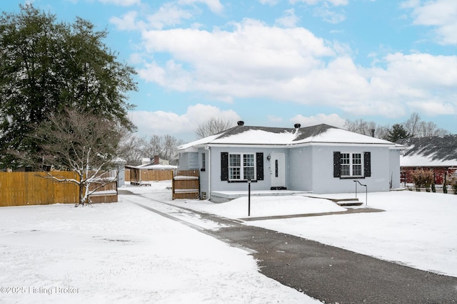 view of front of house with stucco siding and fence