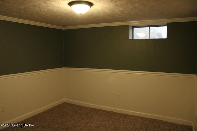 carpeted empty room featuring ornamental molding and a textured ceiling