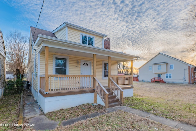 view of front of property featuring a porch and a shingled roof